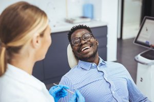 Patient smiling during dental consultation with hygienist, highlighting personalized dental care and comfort at MA's Family & Cosmetic Dentistry.