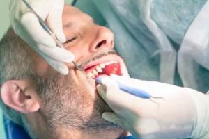 Patient receiving dental examination for TMD treatment, dentist using tools to assess oral health and address bruxism effects.